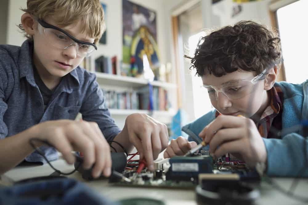 Focused boys assembling circuit board