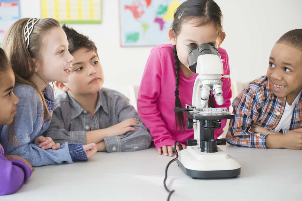 Микро школа. Teacher and children looking in Microscope. Experimental Education.