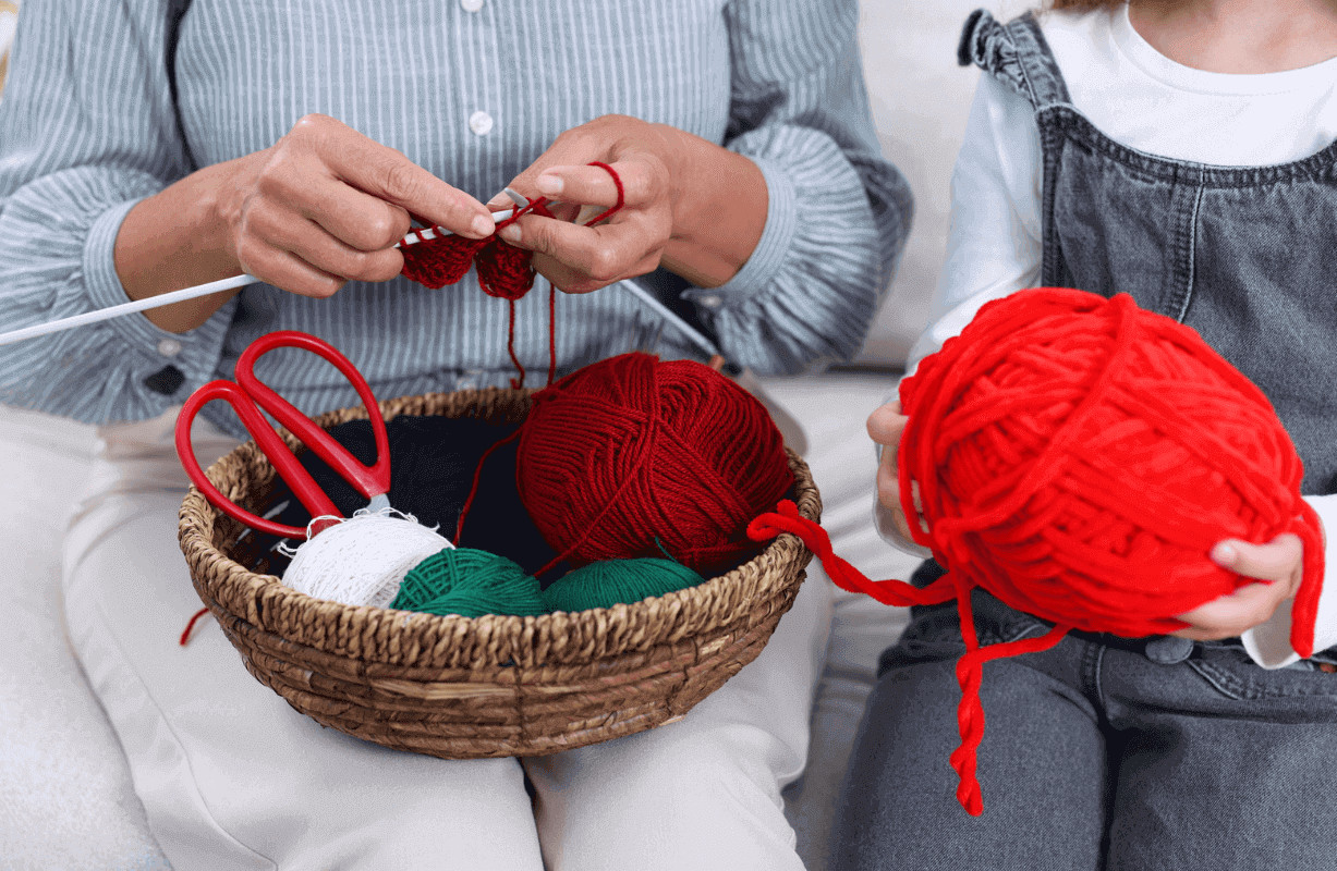 Woman knitting yarn from basket