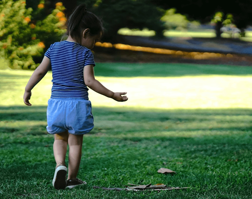 Little girl standing on lush green field in