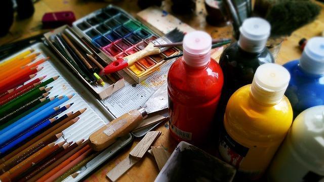 Wooden table with colorful paints for a craft project