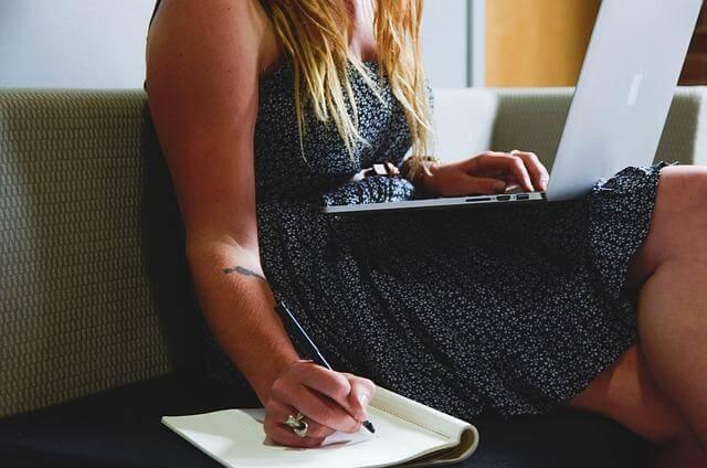 Woman using laptop on couch for work from