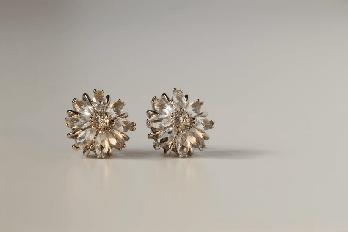 A pair of sparkling diamond stud earrings on a white background.