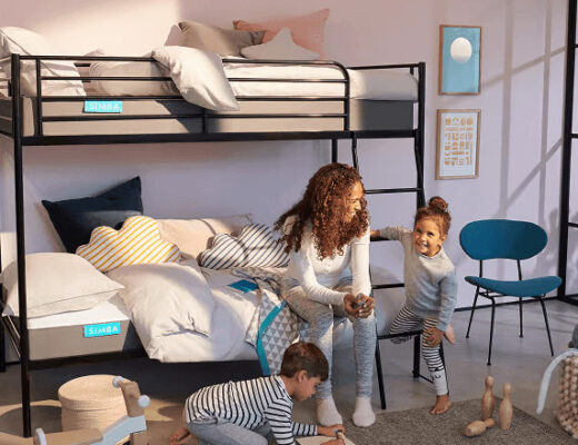 Woman and two children playing on a kids mattress in