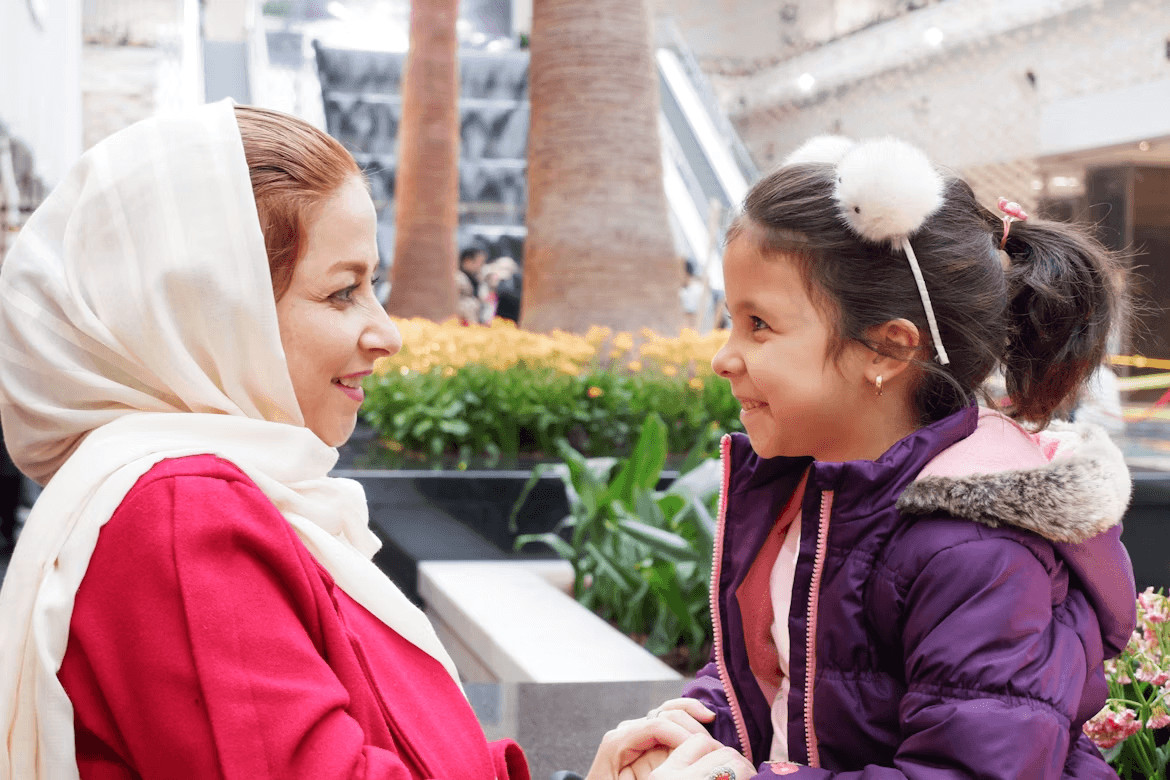 Au pair woman talking to a little girl