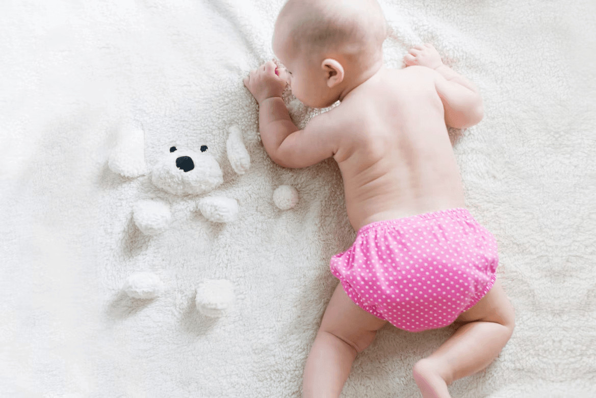 Baby in a diaper laying on a blanket