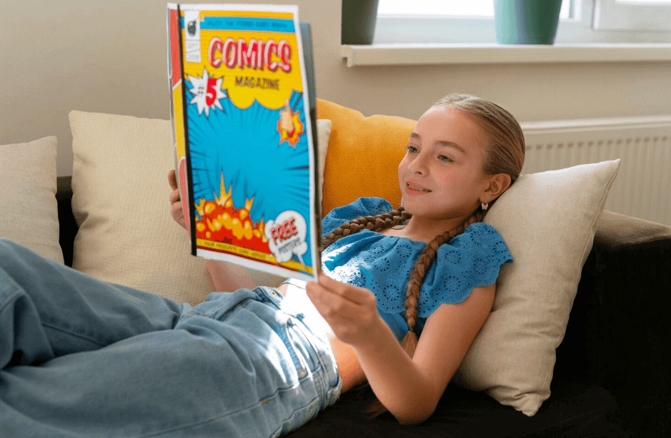 Girl on a couch reading a comic book