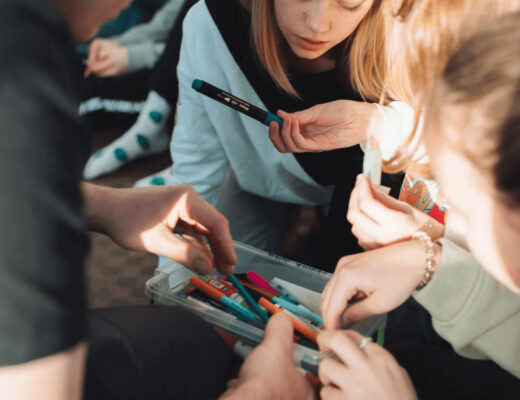 Group of kids holding pencils, collaborating on a creative