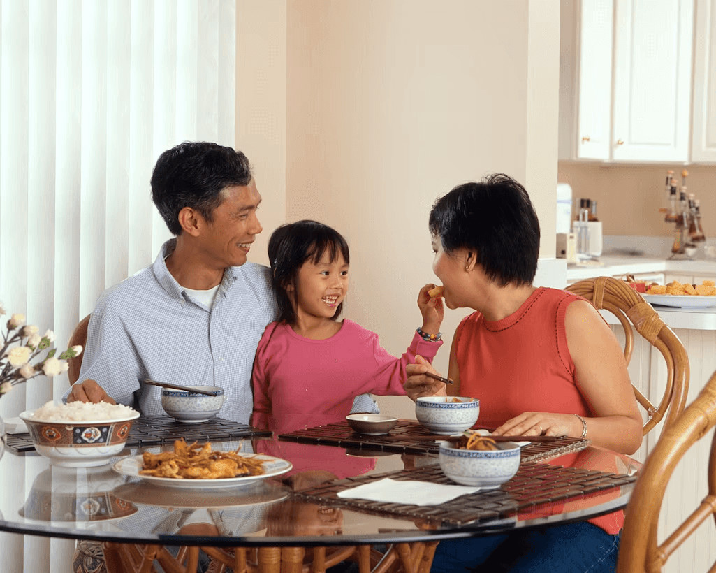 Man and two children enjoying a meal at a table
