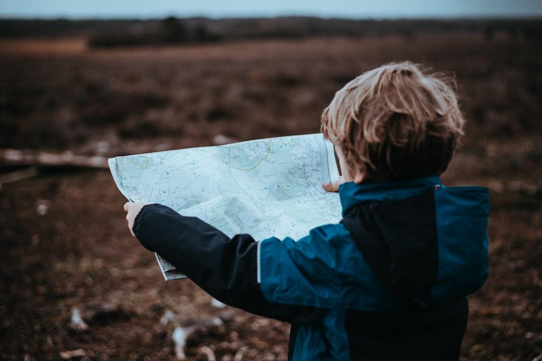 A child holding a paper star chart outdoors at dusk