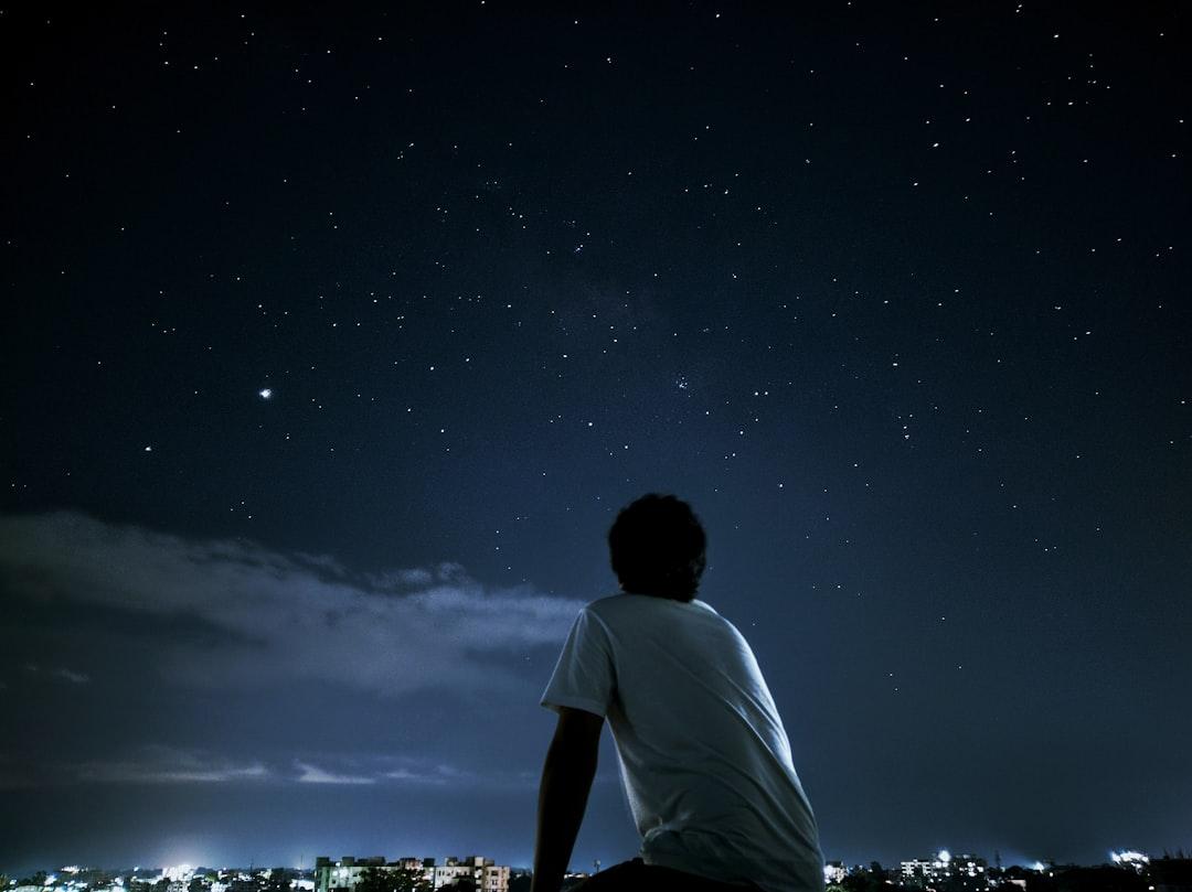 A parent and child looking up at a starry night sky