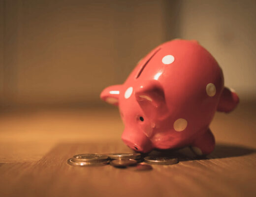Pink piggy bank on a wooden table, symbolizing savings