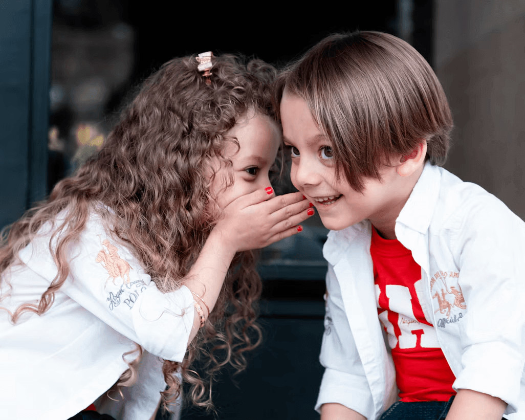 Two kids sitting together, learning to express their